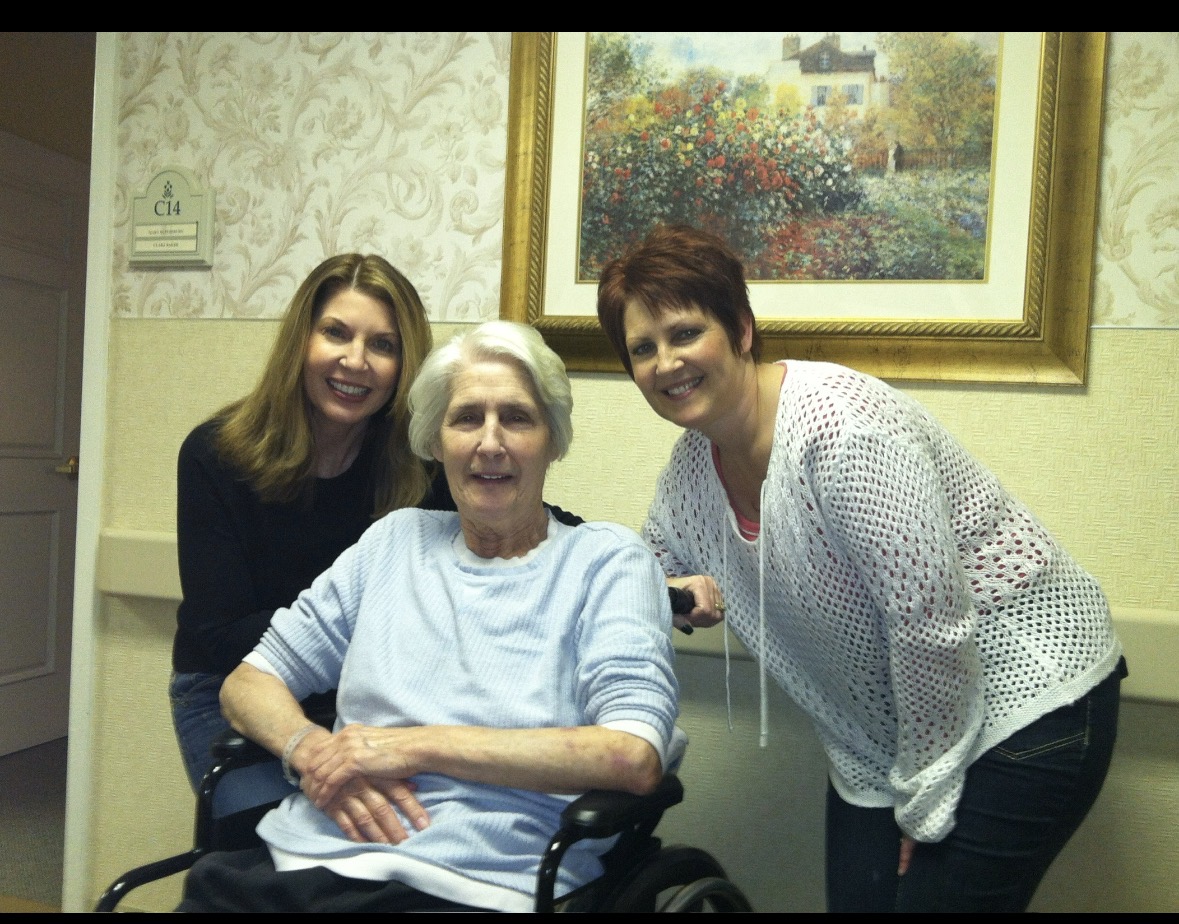 Cathy and her sister smiling beside their mother