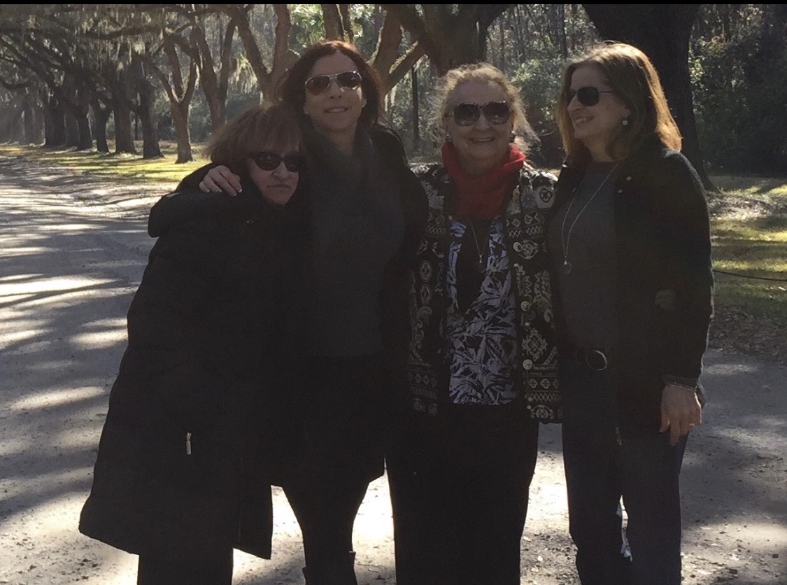 Denise’s mother surrounded by family on a tree-lined path